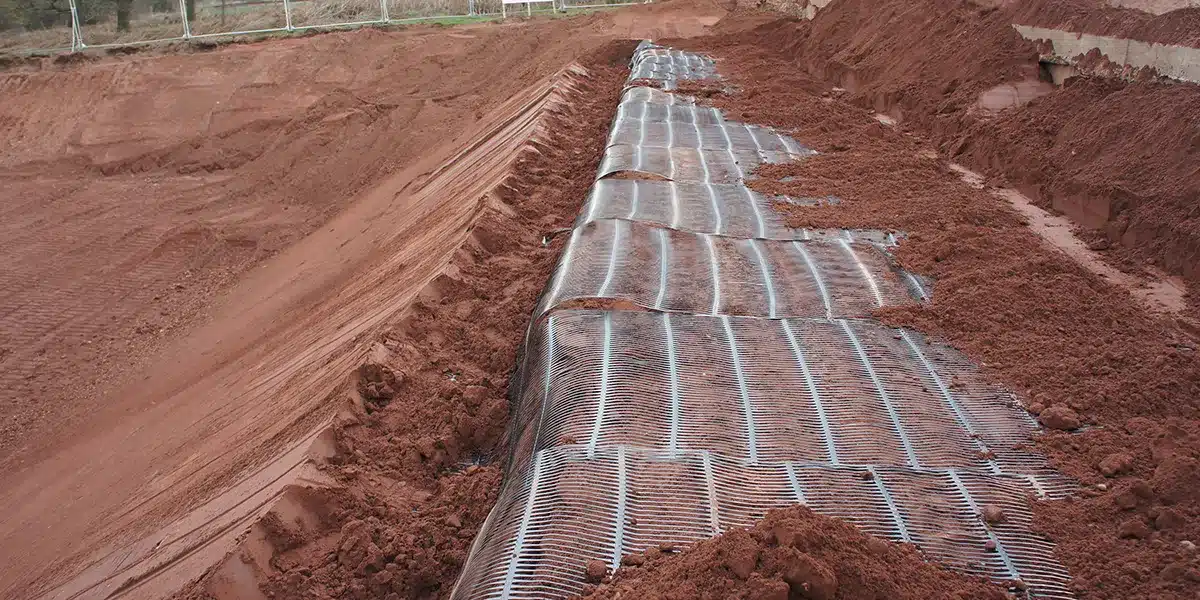 Aplicación de geomalla uniaxial en pavimento vial para reforzar la estructura y prolongar su vida útil.