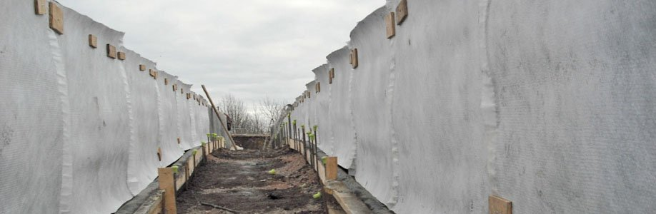 Geocompuesto drenante instalado en muro de contención para drenaje eficiente