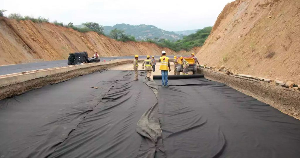 Tela geotextil para mayor estabilidad de la grava. Instalación de tela geotextil bajo grava para separar el suelo y mejorar la estabilidad del camino