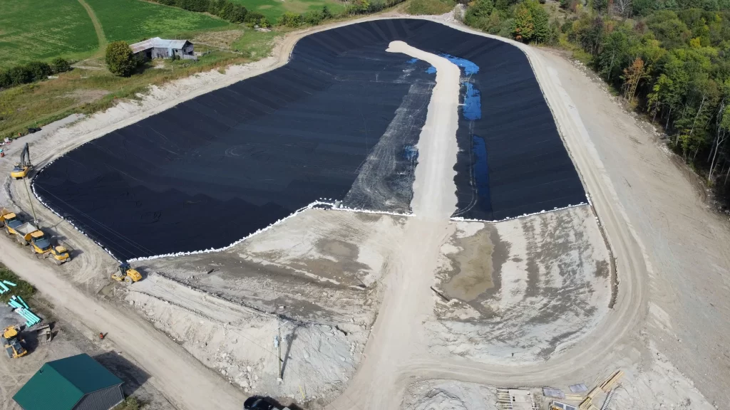 Instalación de geomembrana HDPE en laguna de tratamiento de aguas residuales para controlar filtraciones, aplicación de que es geomembrana.